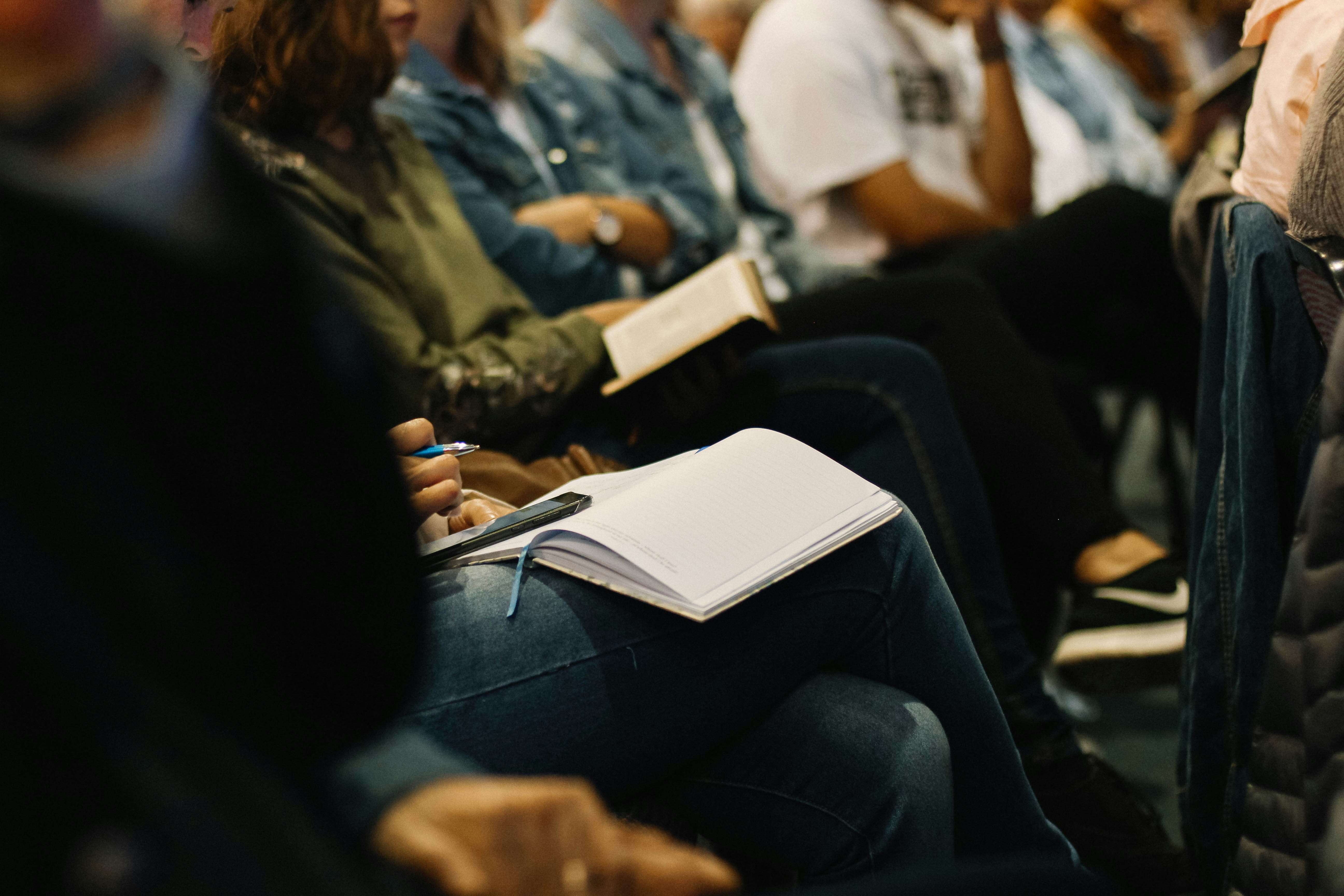 Personas participando y tomando notas durante un encuentro parroquial
